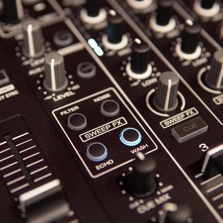 Hands on a sound mixing board during a live production